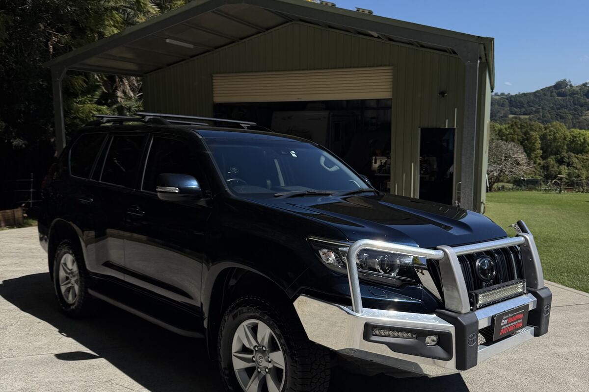 A black Toyota Prado finished by Jayden Nelson, sunlight reflecting off clean paint