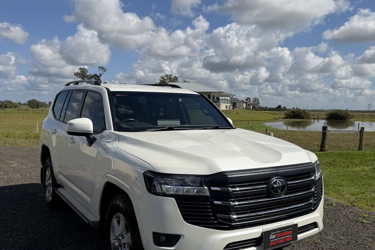 A white Toyota LandCruiser finished by Jayden Nelson, parked by open paddocks